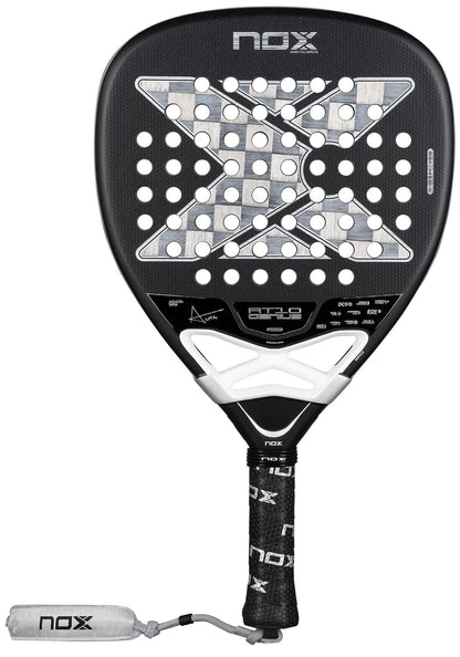 The NOX Luxury AT10 Genius Attack 18K Alum By Agustin Tapia 2026 padel racket features a black design with a large "X," white accents, perforations, a black grip with NOX logo, 18K aluminised carbon build, and white NOX-branded wrist strap.