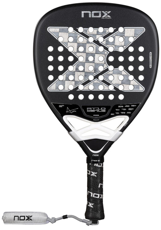 The NOX Luxury AT10 Genius Attack 18K Alum By Agustin Tapia 2026 padel racket features a black design with a large "X," white accents, perforations, a black grip with NOX logo, 18K aluminised carbon build, and white NOX-branded wrist strap.
