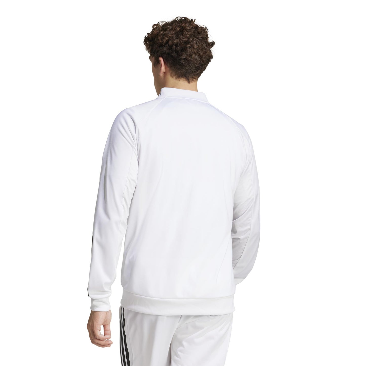 A person with curly hair stands with their back to the camera, showing off a white ADIDAS Men's 3 Stripe Knit Padel Jacket featuring dark stripes on the pants.