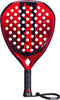 A Babolat Technical Origin + 2026 Padel Racket, featuring a red and black diamond-shaped design with a perforated face, black grip, and attached wrist strap, is displayed against a white background.