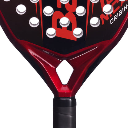 Close-up of the Babolat Technical Origin + 2026 Padel Racket in red and black, distinguished by white circular holes and a signature diamond-shaped cutout near the handle. The racket features a wrapped black grip, highlighting its dynamic design by Babolat and its craftsmanship for precision play.