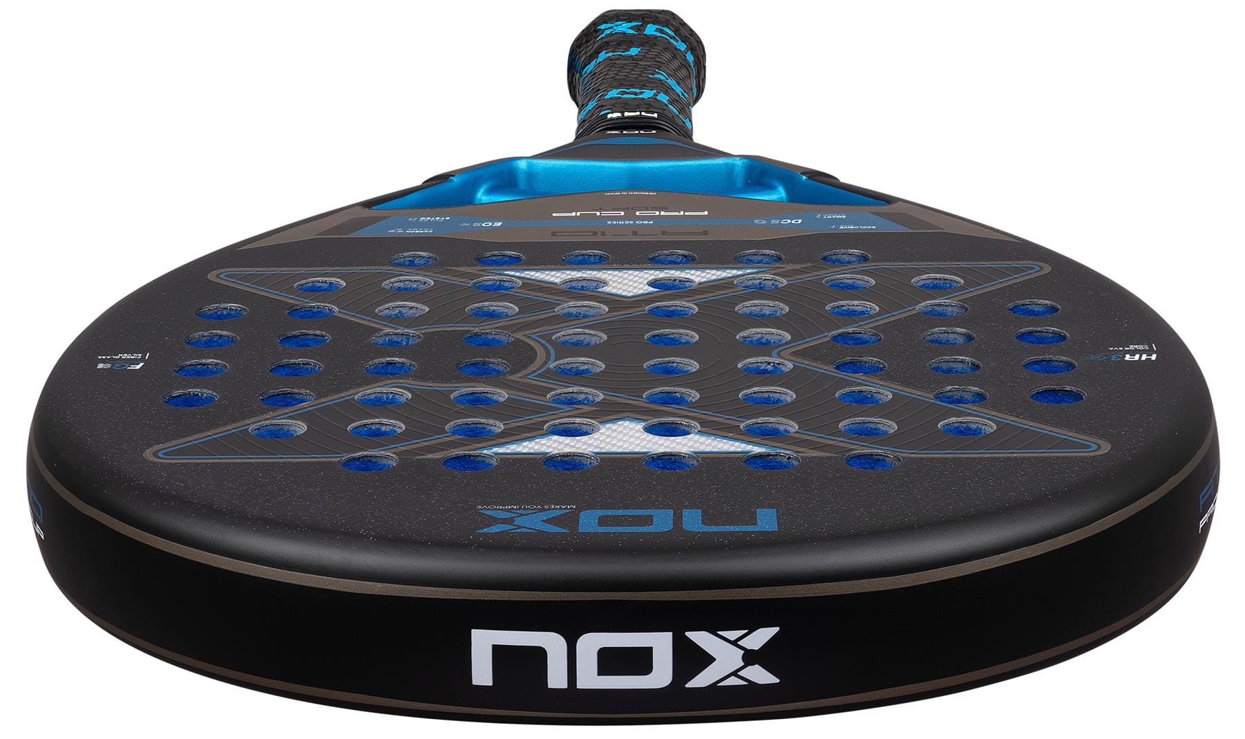 A close-up of the NOX AT10 Pro Cup Soft By Agustín Tapia 2026 Padel Racket shows its perforated black surface with blue accents, the NOX logo, and a handle inspired by Agustín Tapia.