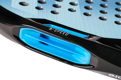 Close-up of the Tecnifibre Curva Soft 2026 Padel Racket, showing its blue and black design with a vent marked “X-SPEED” and raised black dots on the textured blue surface; a detail from this teardrop-shaped racket by Tecnifibre.