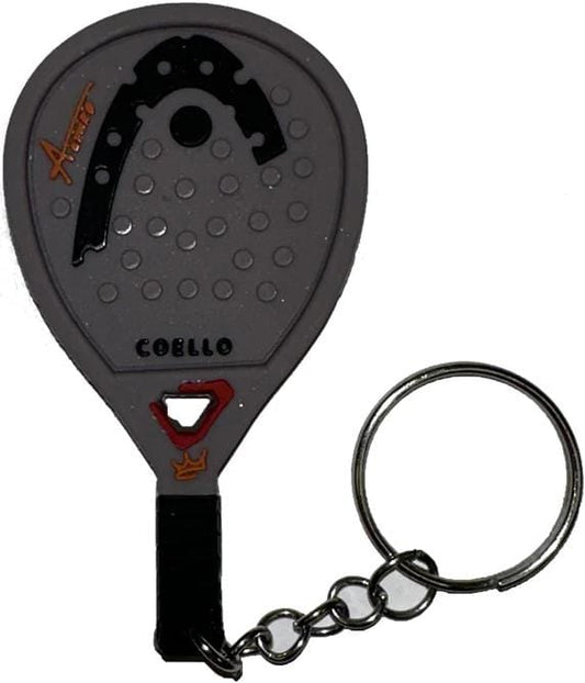 The HEAD Coello 2026 Padel Racket Keyring is a gray padel racket-shaped keychain with circular holes, a black wrist strap, and a metal chain. It features “Avent” and “COBELLO”—a stylish HEAD gift for any padel fan.