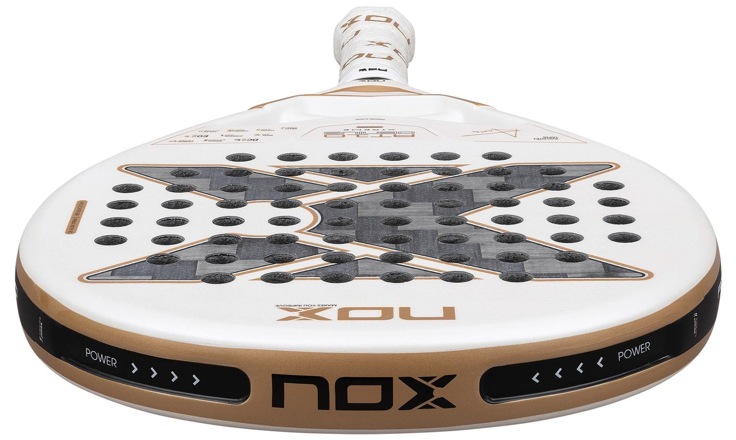 Close-up of the NOX AT10 Genius 12K Alum Extrem By Agustín Tapia 2026 padel racket, featuring a bold black "X" design with holes, gold accents, and "POWER" and "NOX" printed on the edge—Agustín Tapia's signature style.