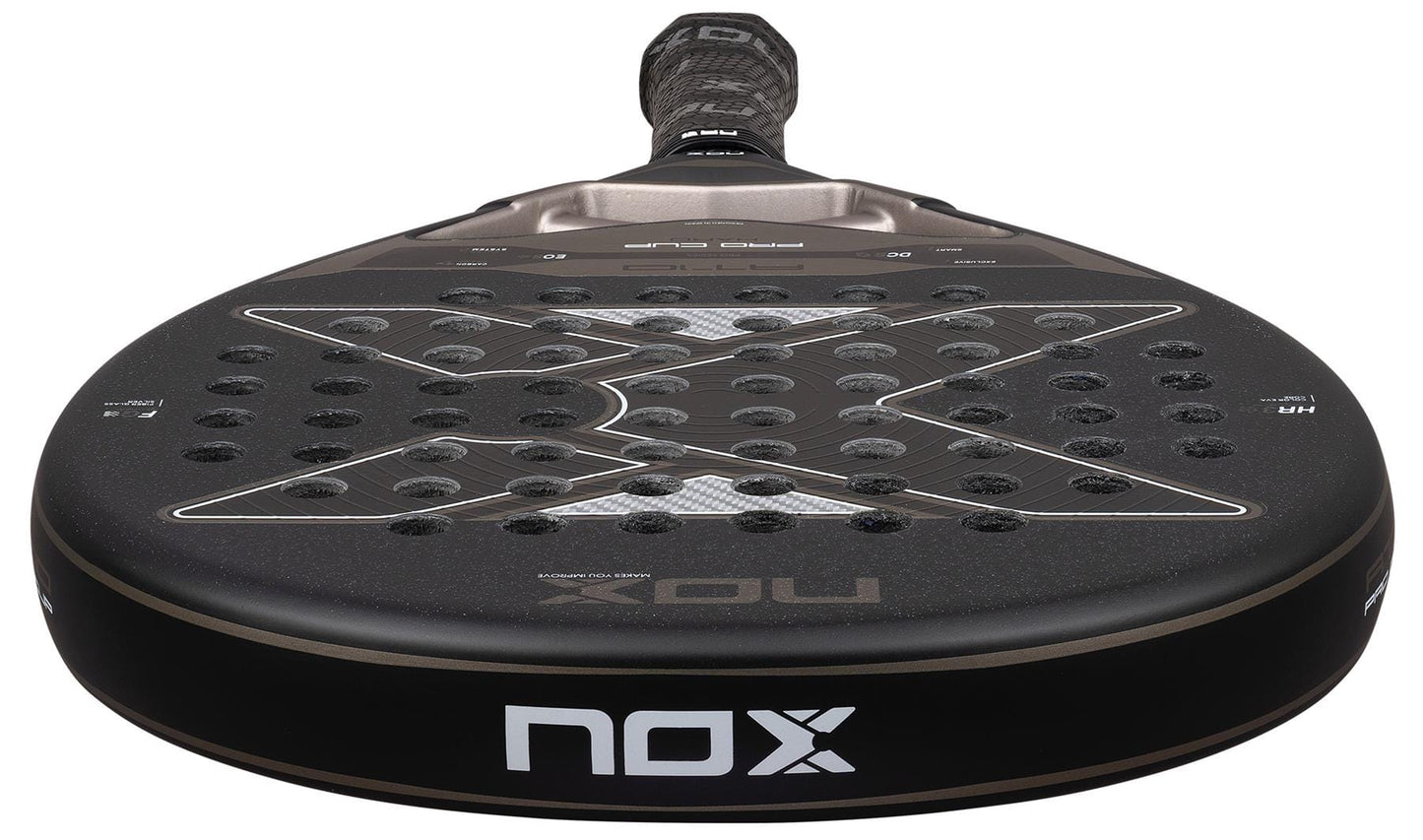 A close-up of the NOX AT10 Pro Cup Hard By Agustín Tapia 2026 padel racket, featuring a black perforated surface with the NOX logo and X-shaped design, handle angled in the background—Agustín Tapia’s top choice.