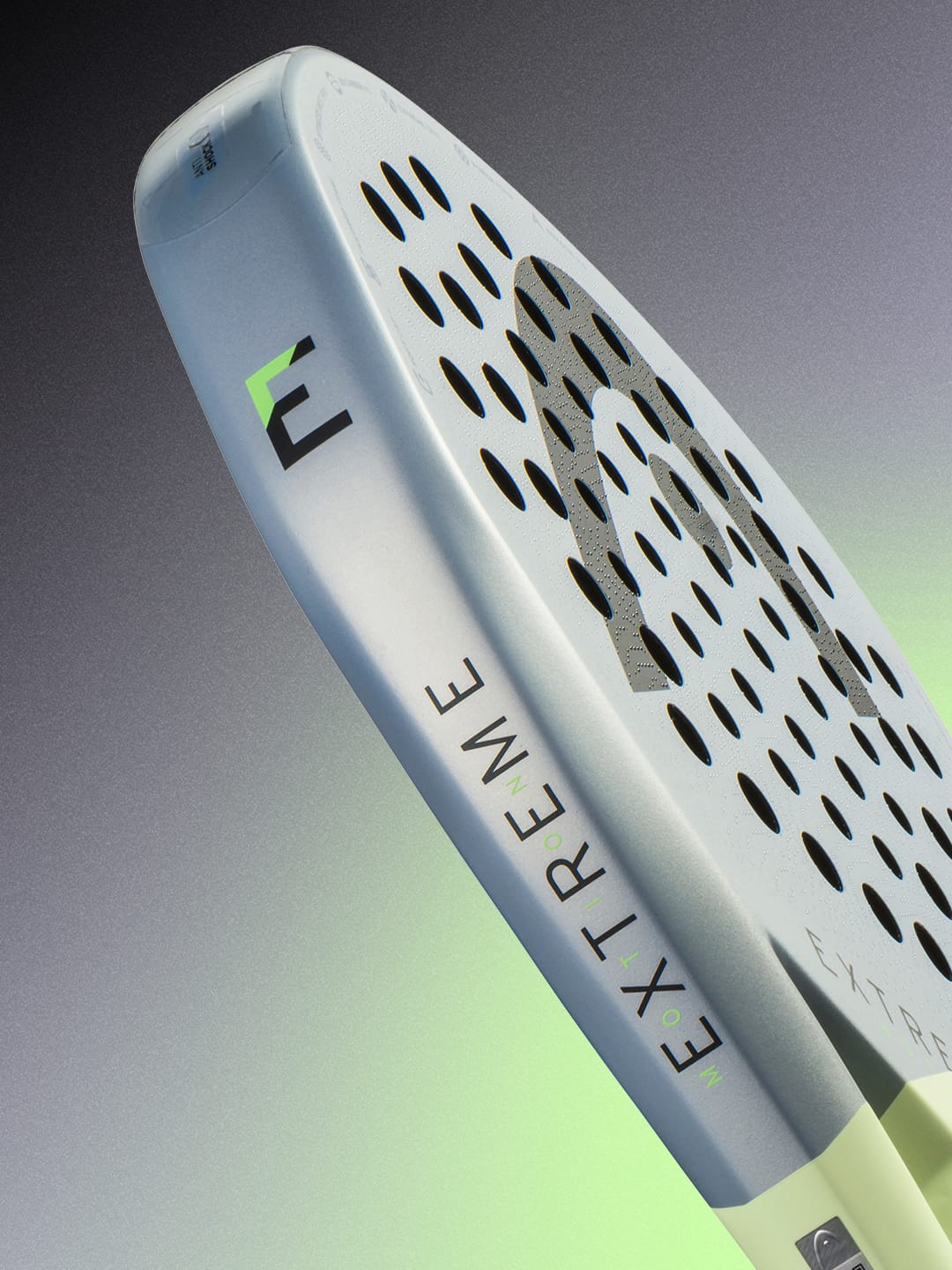 Close-up of the HEAD Extreme Motion 2026 Padel Racket, a high-performance power racket by HEAD for advanced padel players, showcasing a perforated surface with silver and green accents and the word “EXTREME” printed on the side, set against a gradient background.