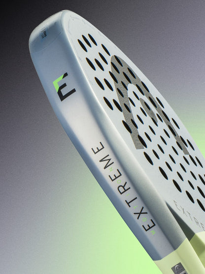 Close-up of the HEAD Extreme Motion 2026 Padel Racket, a high-performance power racket by HEAD for advanced padel players, showcasing a perforated surface with silver and green accents and the word “EXTREME” printed on the side, set against a gradient background.