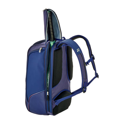 The Yonex 02512EX Expert Padel Backpack in Navy Blue features two main compartments, one partially open to reveal rackets. It's equipped with adjustable padded shoulder straps and side pockets, making it ideal for tournaments and padel or tennis games.