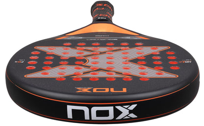 Close-up of the NOX Equation Hard Advanced 2026 Padel Racket by NOX, featuring a black and orange design, anti-vibration system, and large "X" with red circles. Branding appears on the handle and round paddle face.