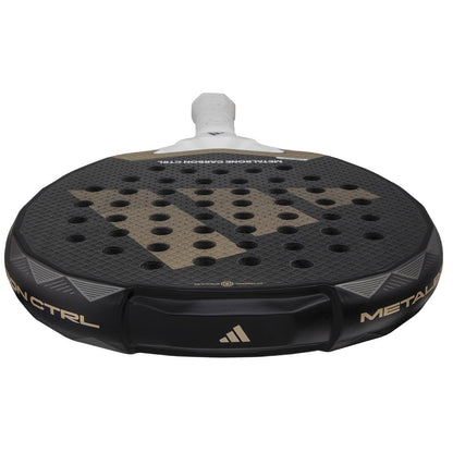 Close-up of a black ADIDAS Metalbone Carbon CTRL 3.4 Padel Racket with a gold "W" logo and multiple holes. The handle is white, and "Metalbone Carbon CTRL" suggests performance and precision for advanced players.