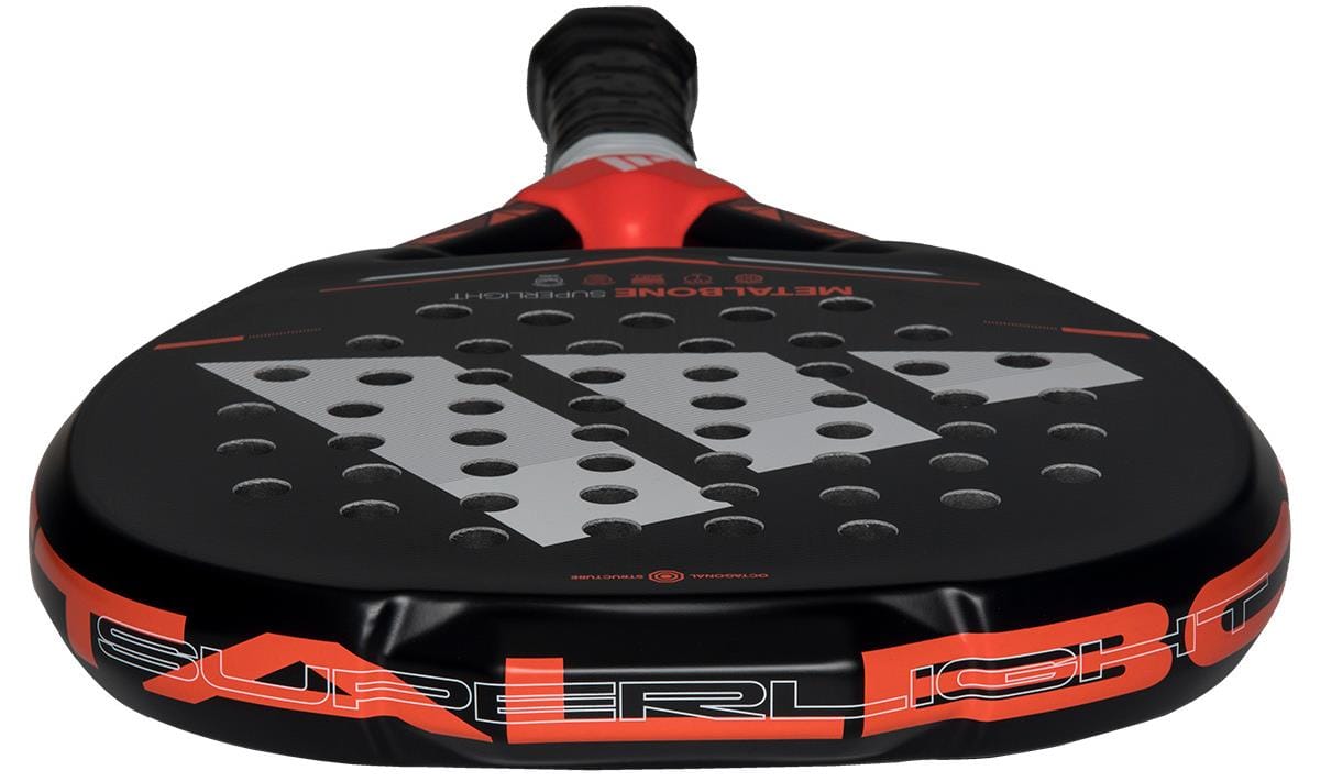 Close-up of the adidas Metalbone Superlight 2026 Padel Racket in black/red, showing its perforated hitting surface and the "SUPERLIGHT" text printed in bold white and orange along the lightweight edge.