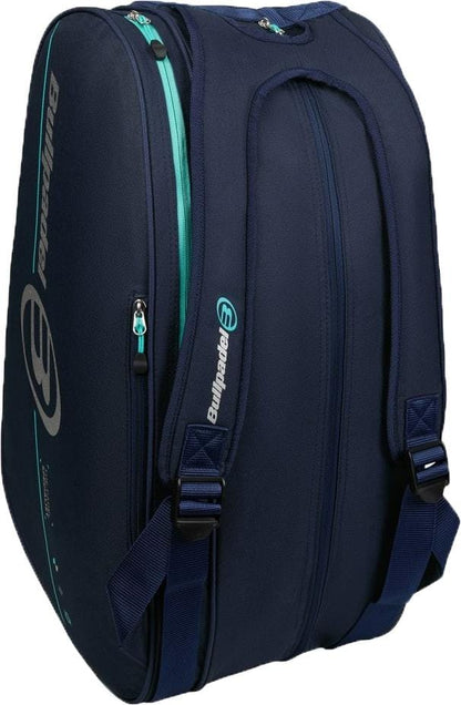 The Bullpadel BPP26015 Tour 2026 Padel Racket Bag in navy features teal accents, dual shoulder straps, several zippered sections including thermal racket compartments, and a prominent Bullpadel logo on the side.