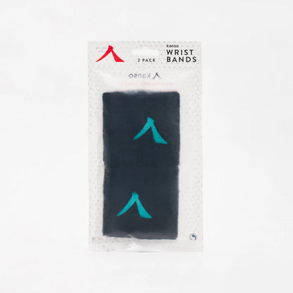 The transparent packaging includes two navy Kanso wristbands made from absorbent fabric, featuring a minimalist teal "K" logo. The plain white background displays the text “Kanso 7cm Wristband - 2 Pack” guaranteeing comfort and style.