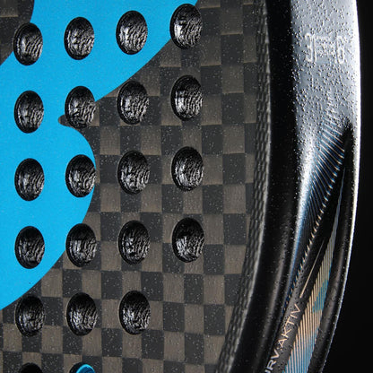 Close-up of the Bullpadel Vertex 05 Hybrid 2026 Padel Racket in black/blue, featuring a checkered carbon fiber pattern, round holes, blue graphic detail, textured surface, and part of a white printed label on its glossy edge.