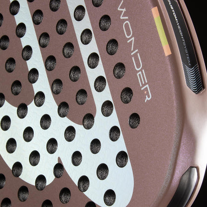 Close-up of the Bullpadel Wonder 2026 Padel Racket - Rose Gold by Bullpadel, featuring a textured rose gold surface, white graphics, circular holes, "WONDER" branding, part of the rim, and Hyper Core details.