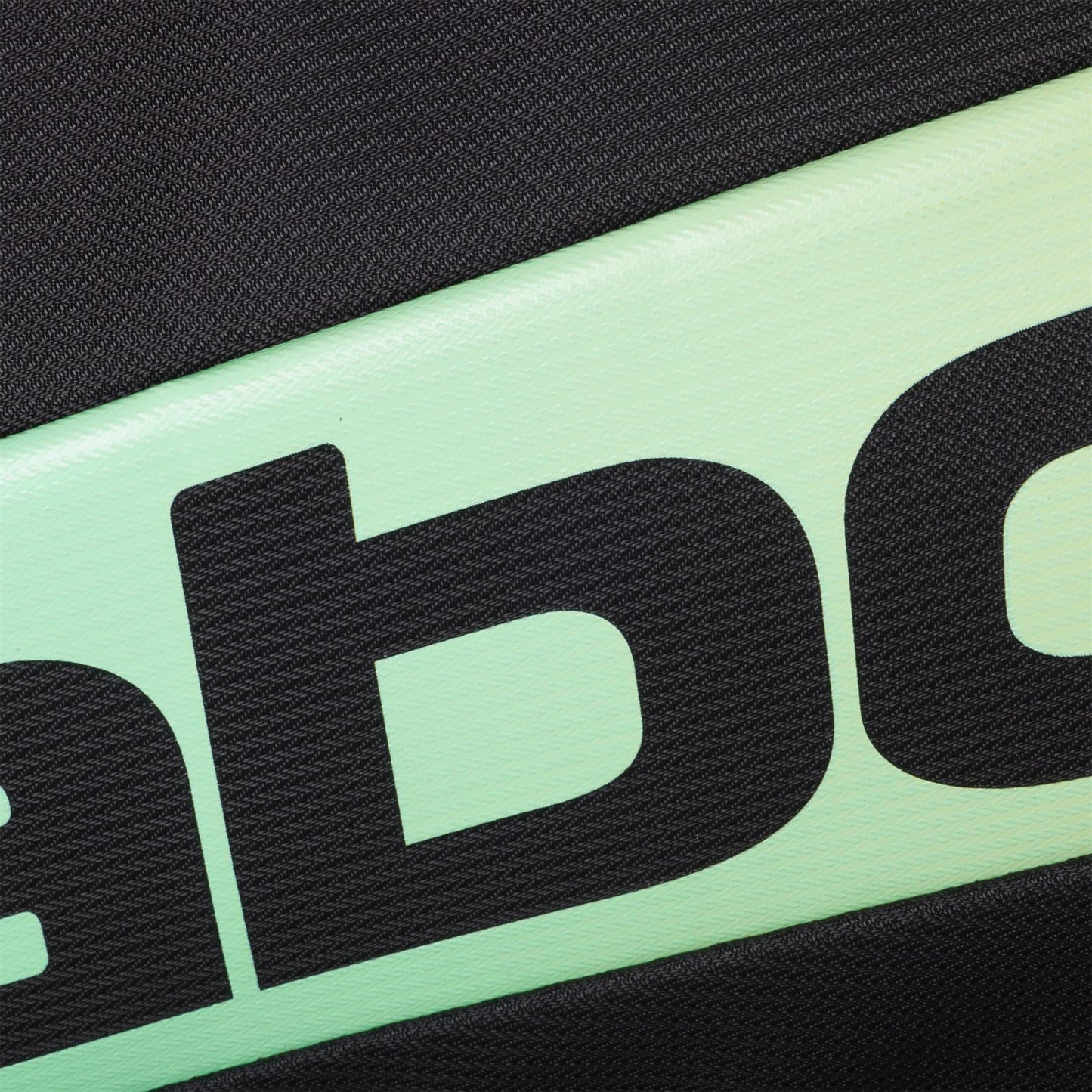Close-up of the textured surface of the Babolat RH Pro 4 Racket Padel Bag (Black / Multi) by Babolat, showing part of large black text on a light green and black background, likely highlighting the insulated racket compartment. Partial letters visible.