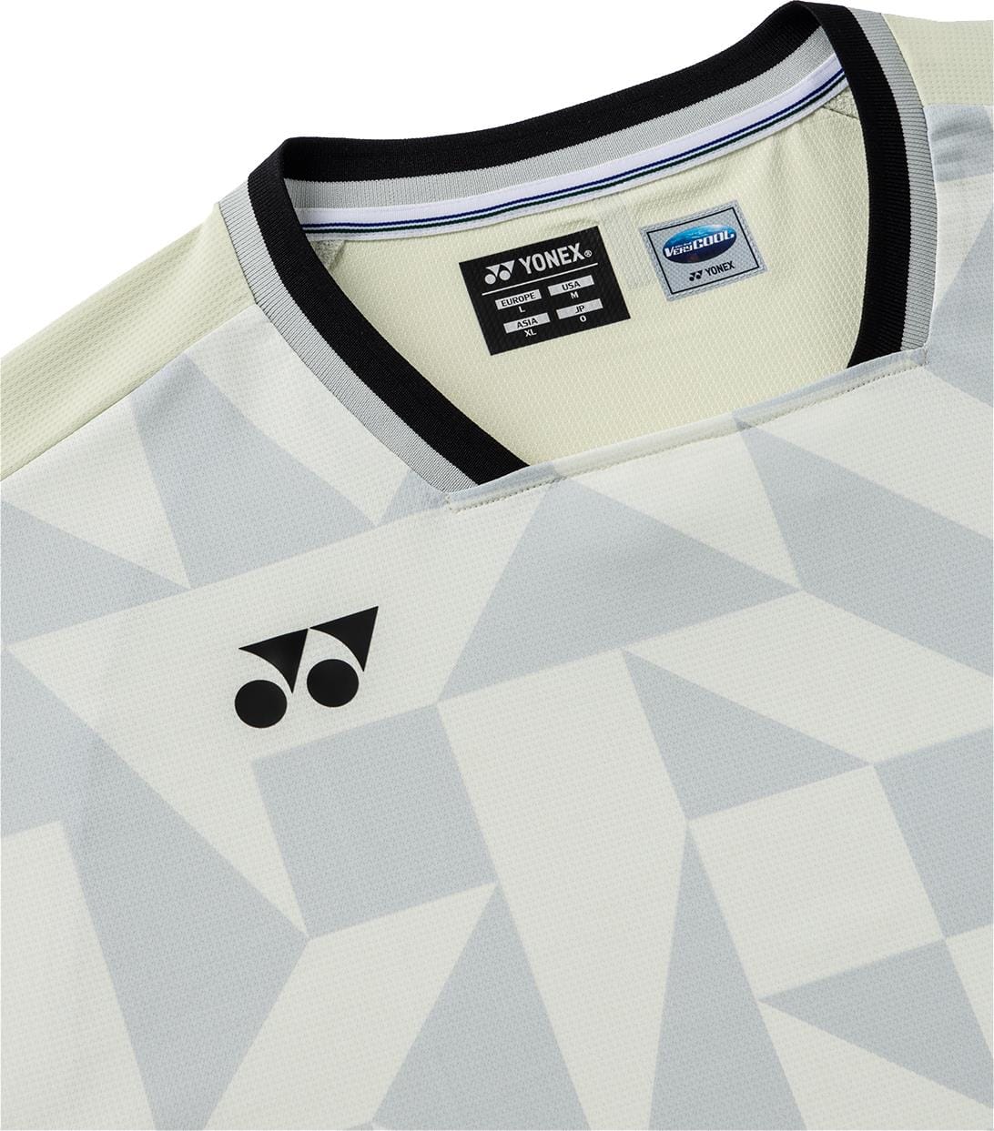 A close-up of the Yonex 10712YX Crew Neck Mens Padel T-Shirt in Champagne, featuring a light gray geometric pattern, Yonex logo on the left, black collar, visible inner tag, and quick-drying fabric for comfort during play.