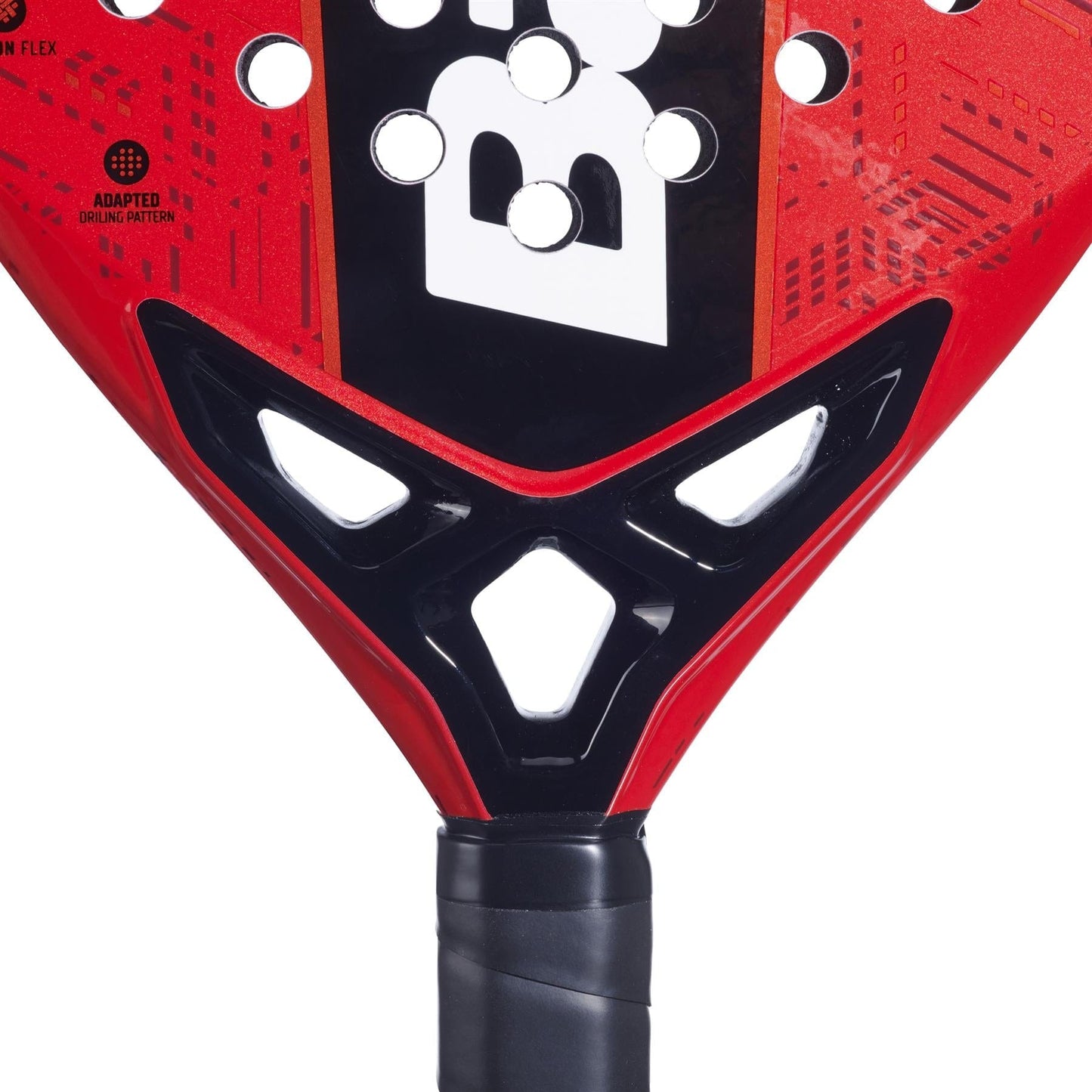 Close-up of the base of the Babolat Alioth Pro Junior Padel Racket in red and black, highlighting the black handle, white geometric cutouts, bold black and white "B" logo, and patterned design by Babolat.