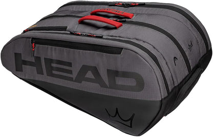 The HEAD Coello Tour Padel Racket Bag L - Dark Grey is a large gray and black bag with striking red handles and zippers, designed with multiple compartments and the signature crown logo on the bottom corner. As part of the exclusive Arturo Coello collection by HEAD, this versatile padel racket bag blends style and functionality, making it ideal for dedicated players.