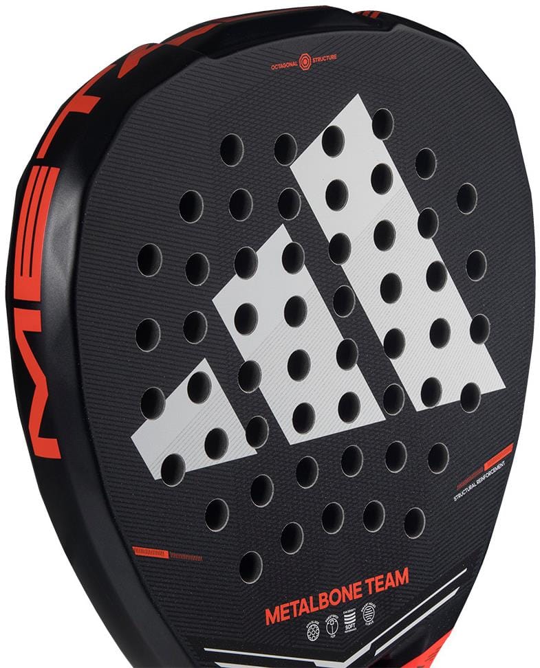 Close-up of the adidas Metalbone Team 2026 Padel Racket in black/red, showing a white logo, Spin Blade Gritt texture, round holes, and red accents. "METALBONE TEAM" text appears near the base of this advanced adidas padel racket.