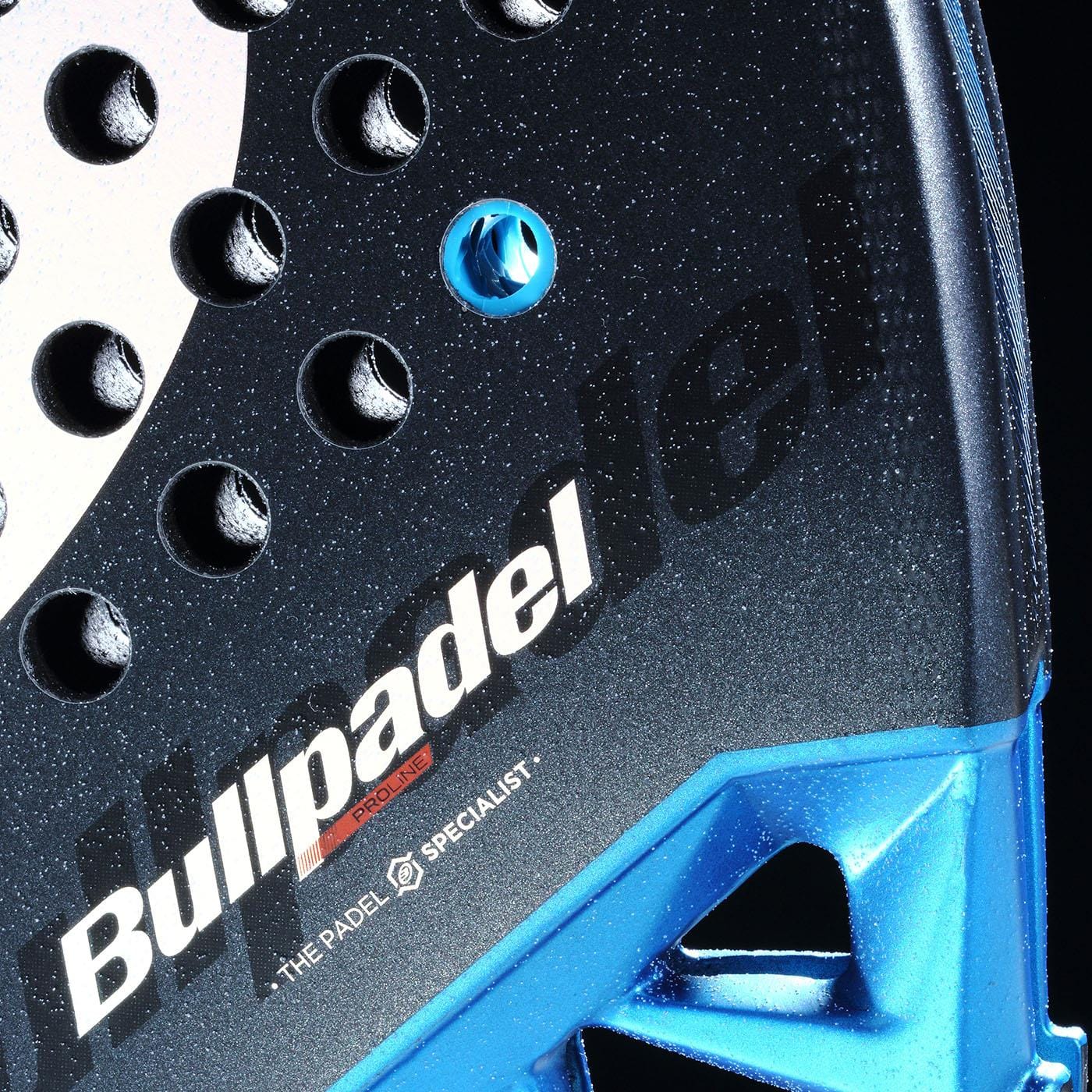 Close-up of the Bullpadel Vertex 05 Comfort 2026 Padel Racket in black/blue, featuring the Bullpadel brand, a textured Fibrix fibre surface with small holes, blue accents, and "THE PADEL SPECIALIST" printed near the bottom.