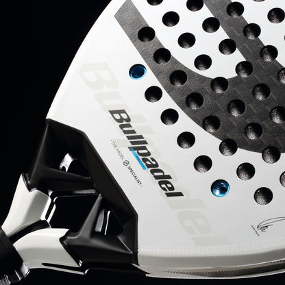 Close-up of the Bullpadel Vertex 05 2026 Padel Racket in white and black, featuring a perforated face, handle detail, and branding against a black background—ideal for high-performance players.