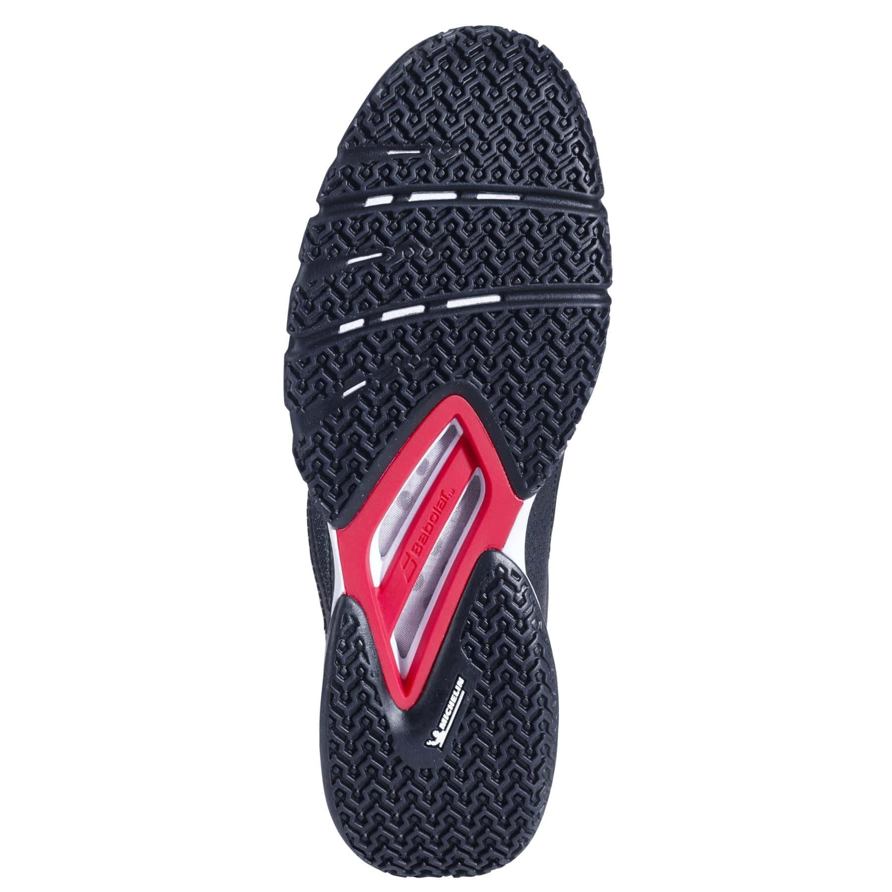 The image shows the sole of the Babolat Jet Premura 2 Mens Padel Shoes in Black/Tomato Red, featuring a textured black rubber pattern, three curved grooves, a red stability shank at the midfoot, and Babolat branding on the arch.