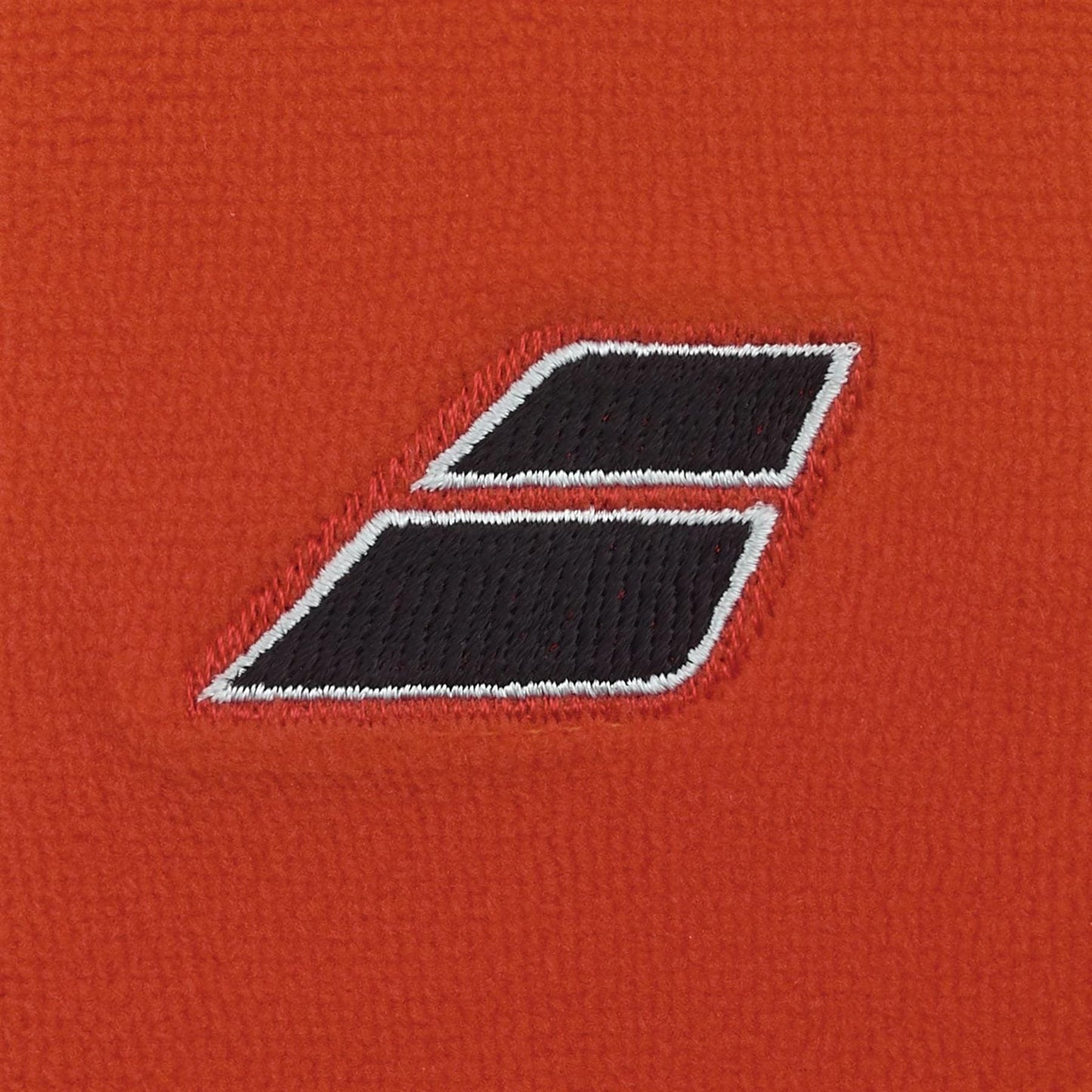 A close-up of the Babolat Terry Jumbo Wristband - Cherry Tomato shows its red fabric and black double-rectangle logo with white outlines—ideal tennis wristbands from Babolat, renowned for excellent sweat absorption.