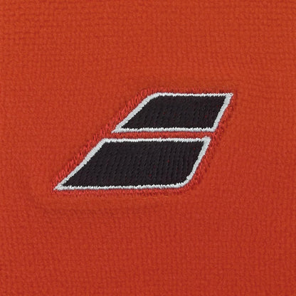 A close-up of the Babolat Terry Jumbo Wristband - Cherry Tomato shows its red fabric and black double-rectangle logo with white outlines—ideal tennis wristbands from Babolat, renowned for excellent sweat absorption.