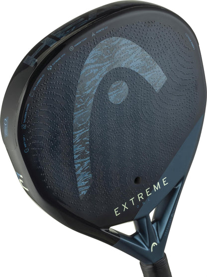 Close-up of the HEAD Extreme One 2025 Padel Racket by HEAD, featuring a black and blue surface with textured patterns, "EXTREME" near the handle, Extreme Spin technology, and a visible 12K Carbon Fibre logo.
