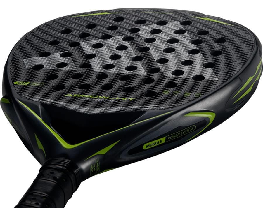 Close-up view of the adidas Arrow Hit Carbon 2026 Padel Racket, showcasing its black and green carbon surface, circular holes, textured detailing, and distinct adidas branding on the edge and handle.