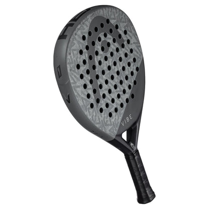 The HEAD Vibe 2025 Padel Racket in grey and black features a patterned, perforated face for improved power. Its fiberglass surface enhances precision, and the handle has a black wrap. The brand name "HEAD" is prominently displayed on the side.