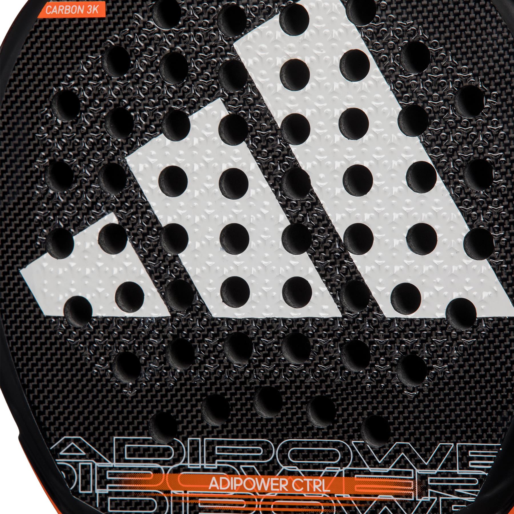 Close-up of the ADIDAS Adipower CTRL 3.3 Padel Racket in black and orange, showcasing a sleek Carbon Fiber 3K texture with a large white logo consisting of three diagonal stripes and small round perforations. "ADIPOWER CTRL" is prominently displayed at the bottom in vibrant orange.