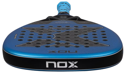 Close-up of the NOX Luxury EA10 Ventus Attack 12K XTREM By Edu Alonso 2026 Padel Racket in blue and black, showing its perforated 12K XTREM Carbon surface, textured grip handle, and prominent NOX branding on the face and edge.