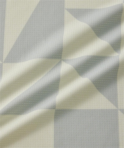 A close-up of the Yonex 10712YX Crew Neck Men's Padel T-Shirt in champagne, showing its textured geometric fabric with light beige and pale gray tones, creases, and soft folds typical of quick-drying Yonex sportswear.