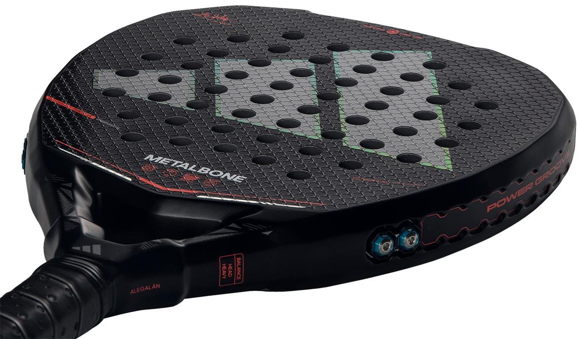 A close-up of the adidas Metalbone by Ale Galán 2026 Padel Racket - Black shows its hexagonal pattern, circular holes, green and red accents, Spin Blade Decal, "METALBONE" branding near the handle, and innovative adjustable weight system.