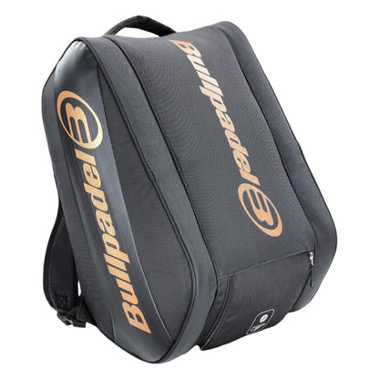 The Bullpadel Vertex 25 Padel Racket Bag in black boasts a gold logo, ventilated compartment for freshness, large central section, adjustable shoulder straps, and a front zip pocket—ideal for technical racket storage or casual use.