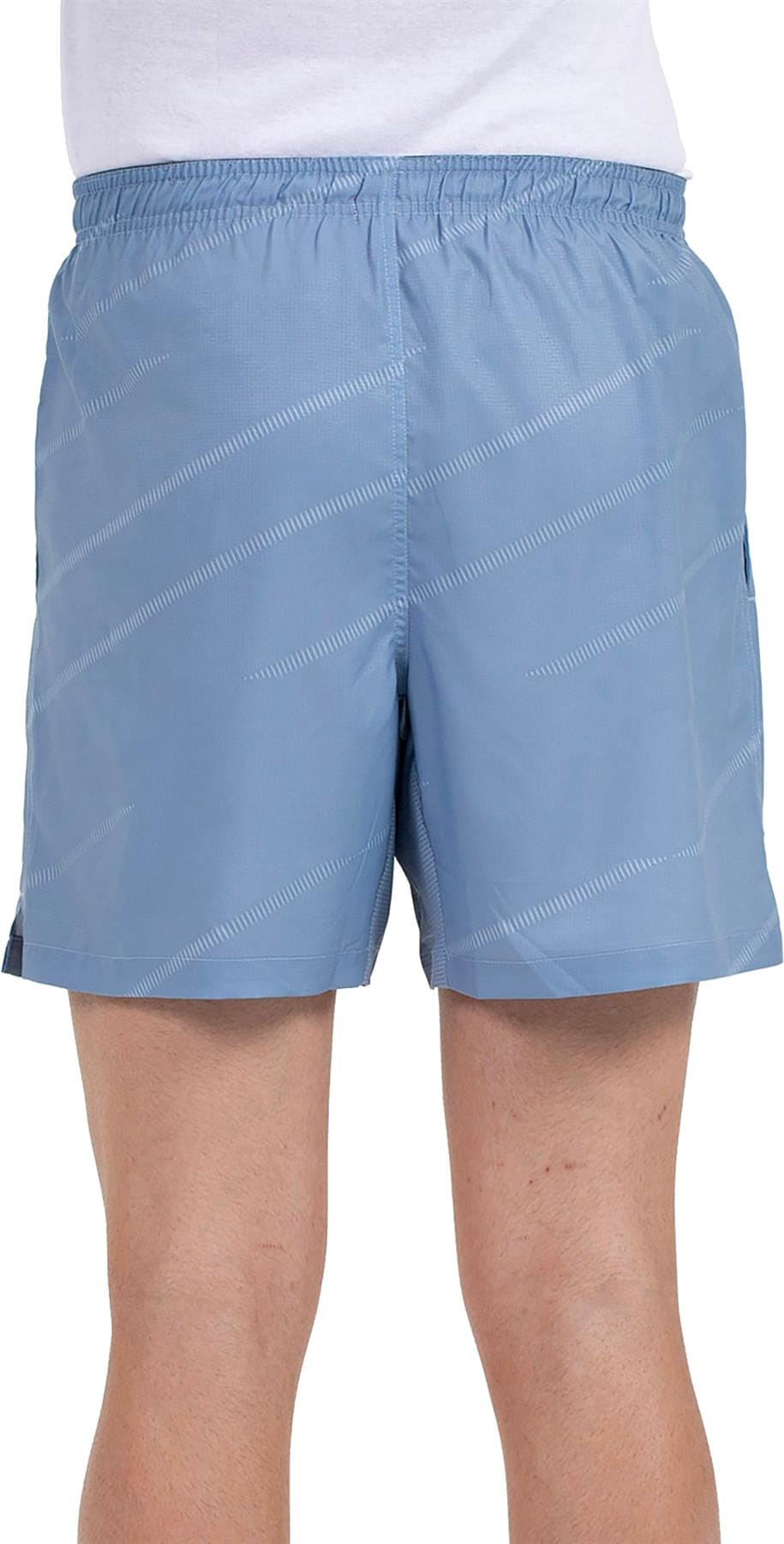 A person wears Bullpadel Cabanas Mens Padel Shorts in shadow blue, featuring a subtle diagonal stripe, elastic waistband, and Quickerdry tech for comfort and dryness—perfect for enhancing padel court performance.