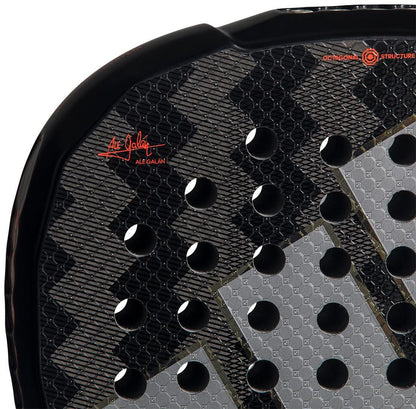 Close-up of the adidas ADIDAS Metalbone by Ale Galán 2026 Padel Racket in black, showing textured gray design, circular holes, red signature, geometric patterns, and an innovative adjustable weight system.