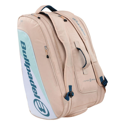 A pink Bullpadel Elite 25 padel racket bag featuring thermo-lined compartments and adjustable straps. This sleek bag, displaying the brand's logo, is designed for gear transport with a style inspired by Gemma Triay.