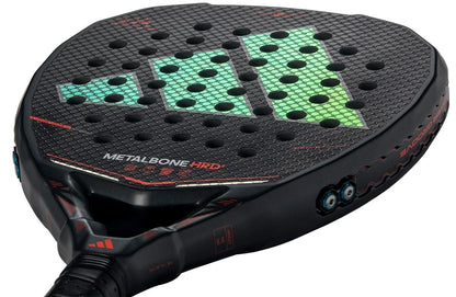 Close-up of the adidas Metalbone HRD+ by Ale Galán 2026 padel racket in black/red, featuring a honeycomb pattern, green geometric design, red accents, "METALBONE HRD" text, and adjustment screws for elite power performance.