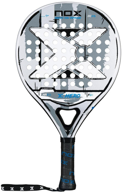 The NOX X-Hero White Padel Racket features a black, white, and gray design with a large central X, round holes on the head, and a black grip handle with an attached wrist strap.