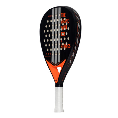 The ADIDAS Match Black 3.4 Padel Racket - Black / Orange by adidas features a black frame with white grip tape, red and white "THE BRAND WITH THE 3 STRIPES" text, an orange triangular design, circular perforations, hybrid head shape, and EVA Soft Performance foam for optimal play.