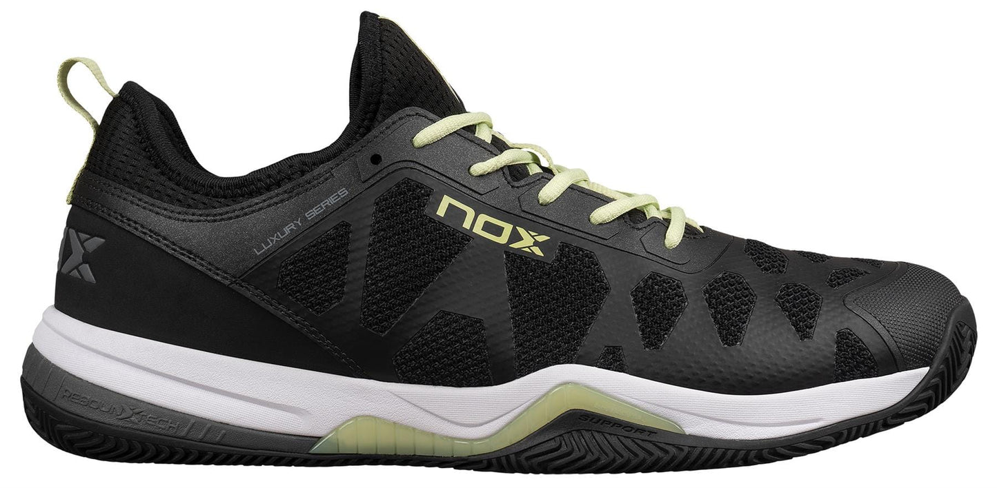 The NOX Nerbo Men's Padel Shoes in black/soft lime feature light green laces, a white midsole, black outsole, “NOX” branding, a textured design, Ortholite insole for comfort, and reinforced heel and toe caps for durability.