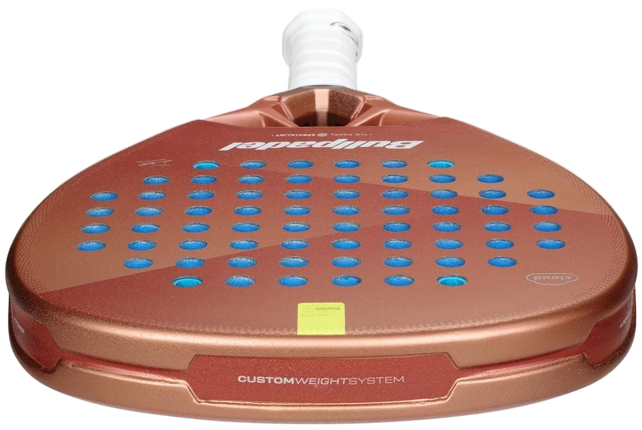 The Bullpadel Vertex 05 W Cloud 2026 padel racket features a metallic bronze design with blue holes, a white handle, and "CUSTOMWEIGHTSYSTEM" plus "Bullpadel" printed on its face and edge for enhanced comfort.