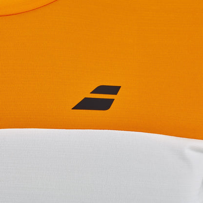 Close-up of the Babolat Crew Neck Mens Padel T-Shirt in Orange / Cream, featuring an orange upper section, a cream lower section, and a small black geometric logo with two angled bars on the chest—a stylish example of premium padel clothing by Babolat.