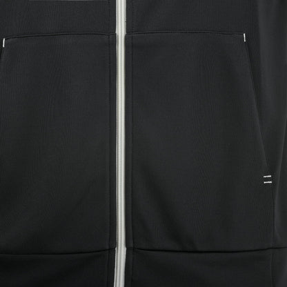 Close-up of the Babolat Perf Men’s Padel Jacket in black, featuring a white zipper and two front pockets with a minimalistic design and subtle stitching details. This lightweight, breathable men’s padel court jacket from Babolat offers optimal comfort and style on the court, making it an excellent choice for players seeking both functionality and a sleek look.