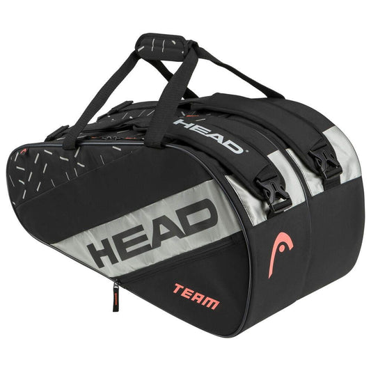 The HEAD Team Padel Bag L - BKCC is a sleek black and gray padel bag with the "HEAD" logo prominently displayed. This lightweight design features multiple compartments for rackets, two sturdy handles on top, and subtly displays the word "TEAM" near the bottom.