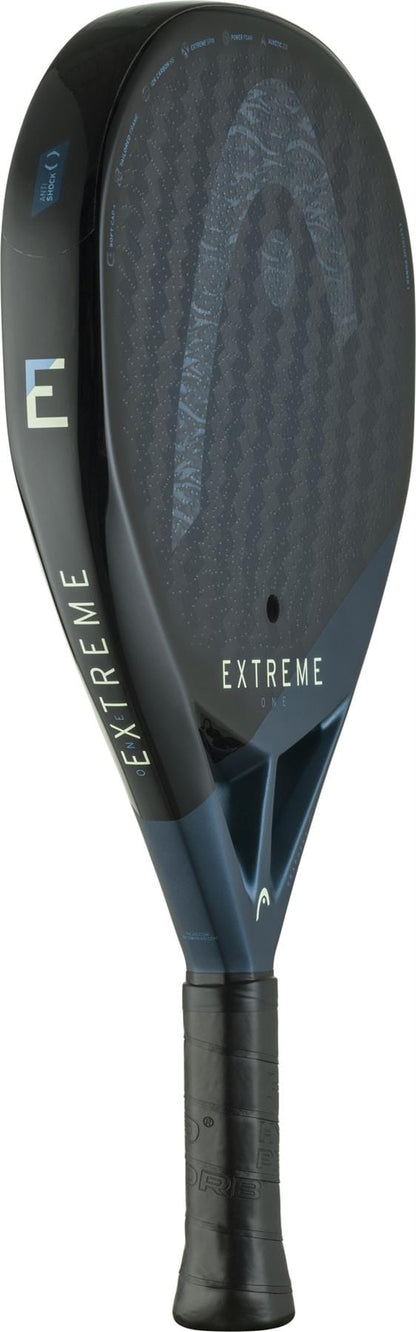 The HEAD Extreme One 2025 Padel Racket in black/blue features a textured 12K carbon fiber surface, Extreme Spin technology, "EXTREME ONE" labeling, a small "F" logo, and a black-gripped handle for enhanced performance.